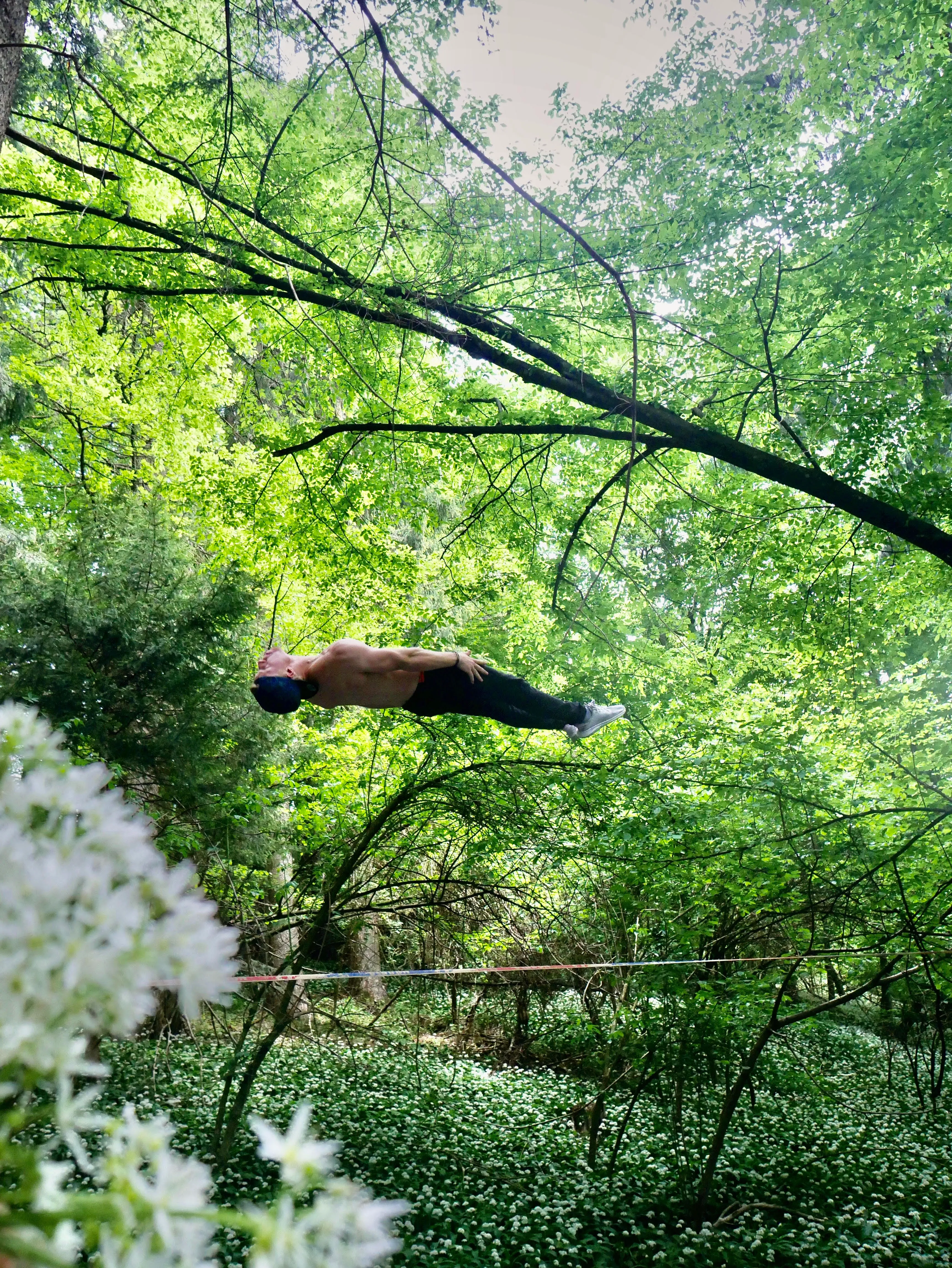 Backflip auf der Slackline im Wald